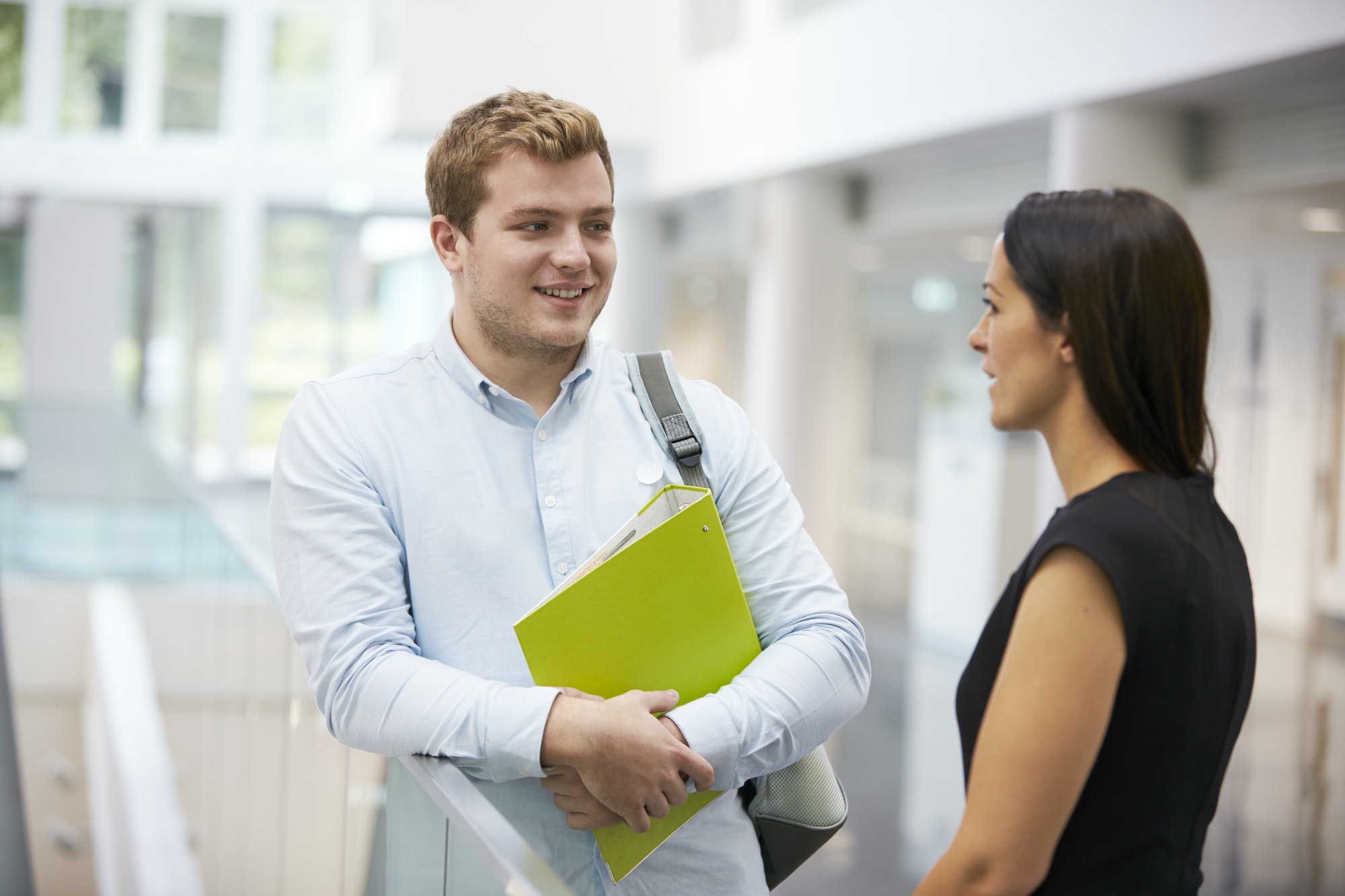 Adult student and teacher talking in university foyer