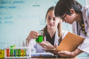 Couple of students working at chemistry class. Education concept