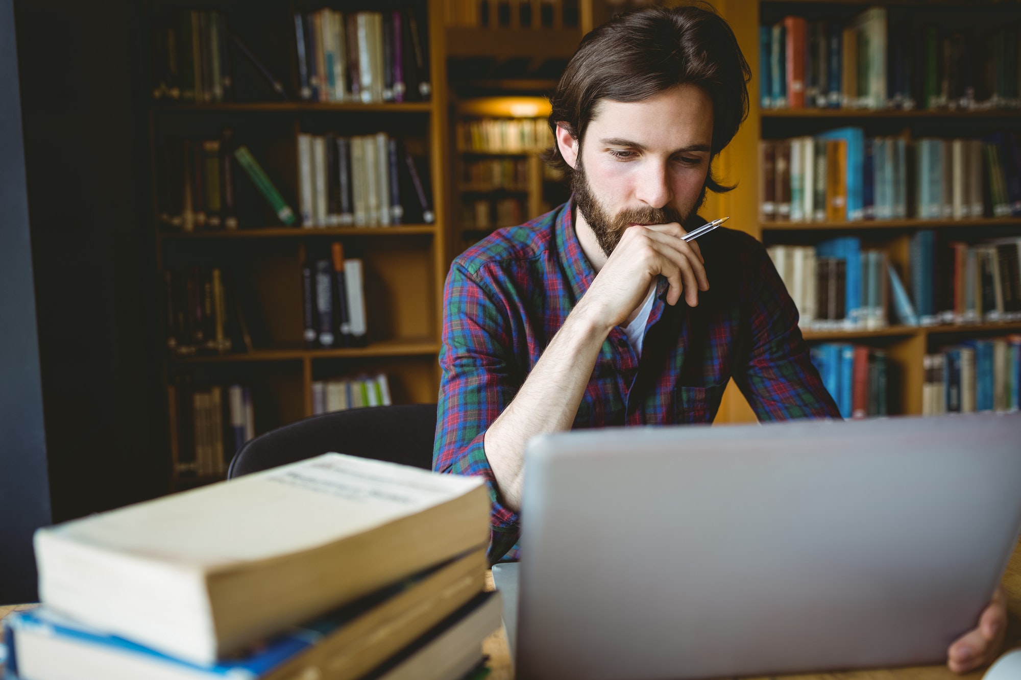 Hipster student studying in library at the university